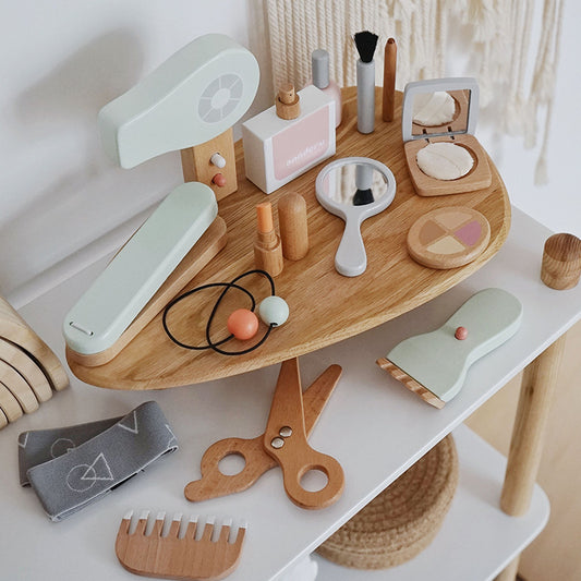 Wooden toy vanity set with various accessories on a white surface