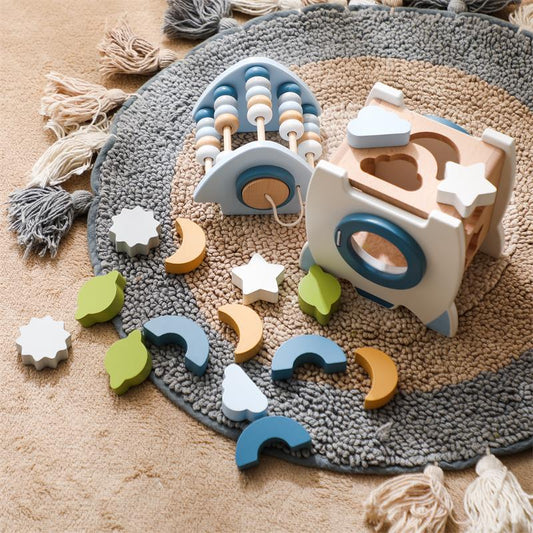 Wooden toys on a textured rug with colorful geometric shapes.
