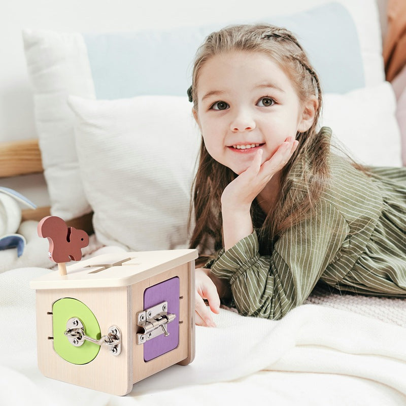 Young girl playing with a wooden toy box on a bed
