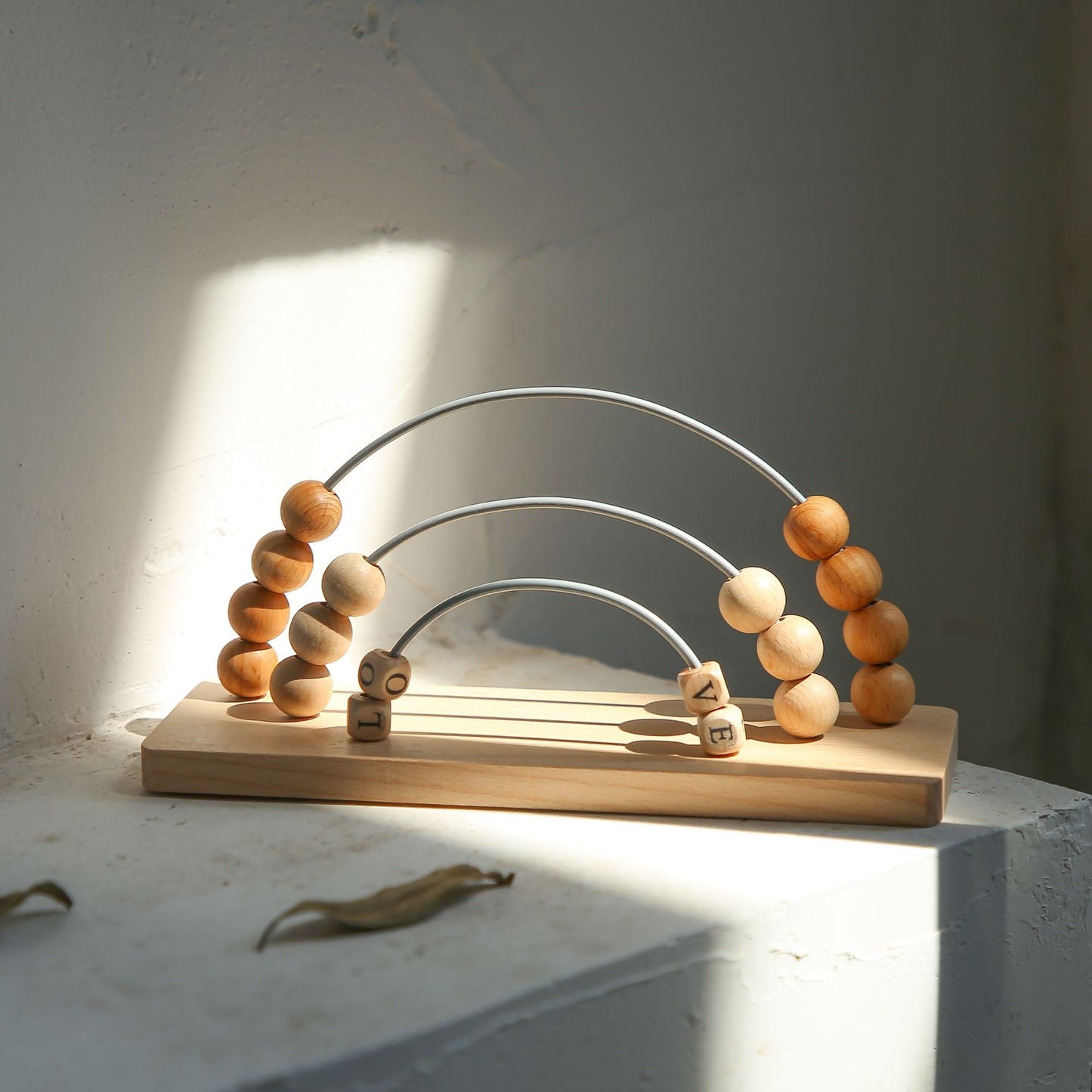 Wooden toy arch with beads on a light surface