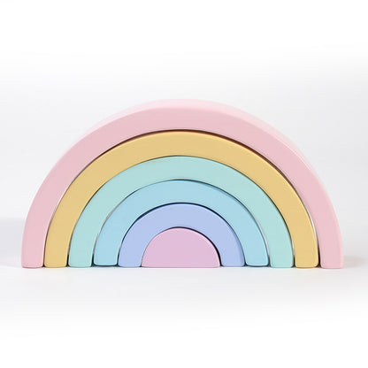 Pastel-colored wooden rainbow toy on a white background