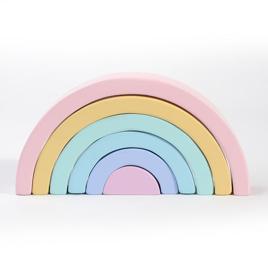 Pastel-colored wooden rainbow toy on a white background