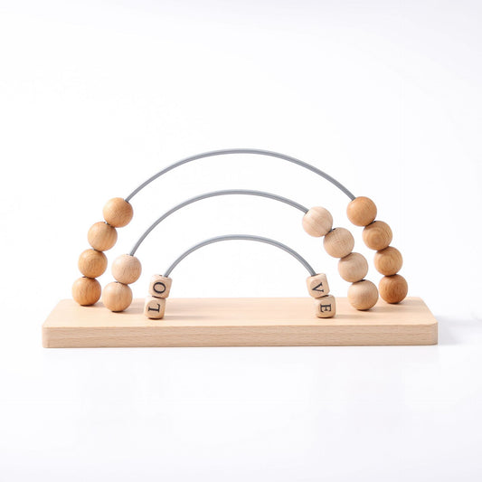 Wooden toy with beads and letters spelling 'LOVE' on a white background