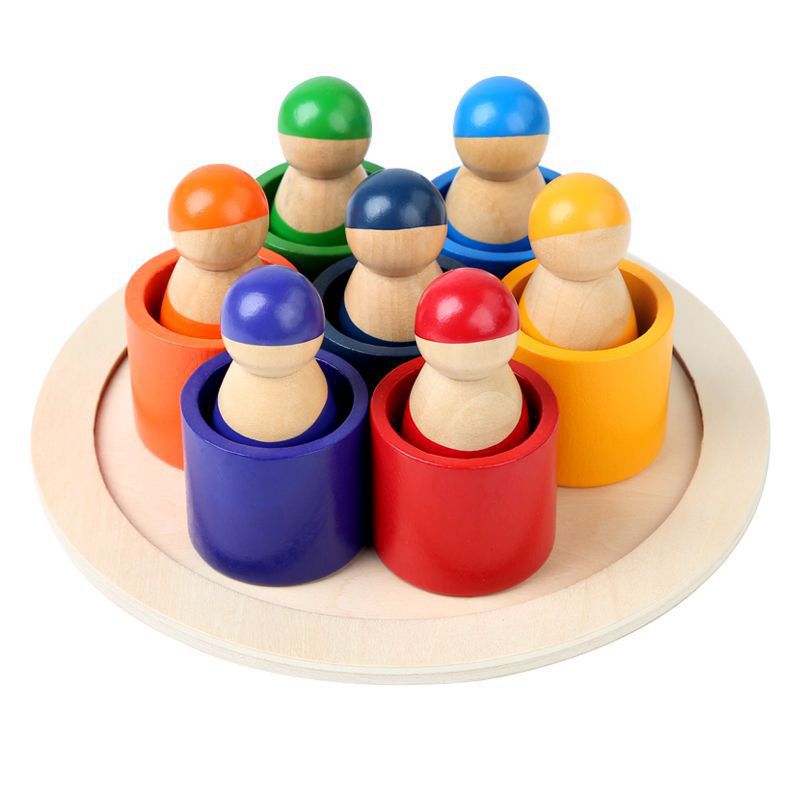 Colorful wooden peg people in variously colored cups on a round wooden base.
