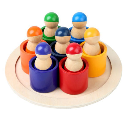 Colorful wooden peg people in variously colored cups on a round wooden base.