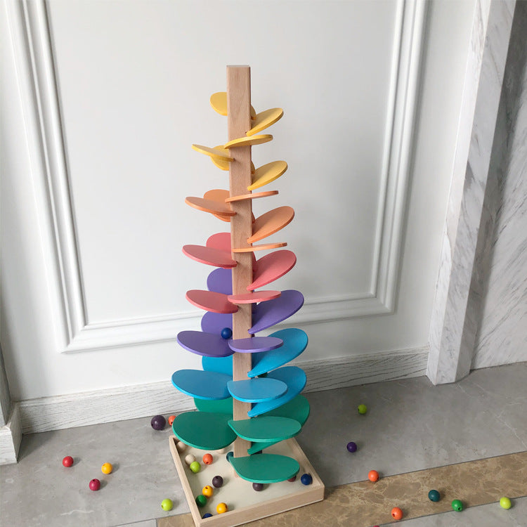 Colorful wooden toy with spiral design on a light gray floor against a white wall.