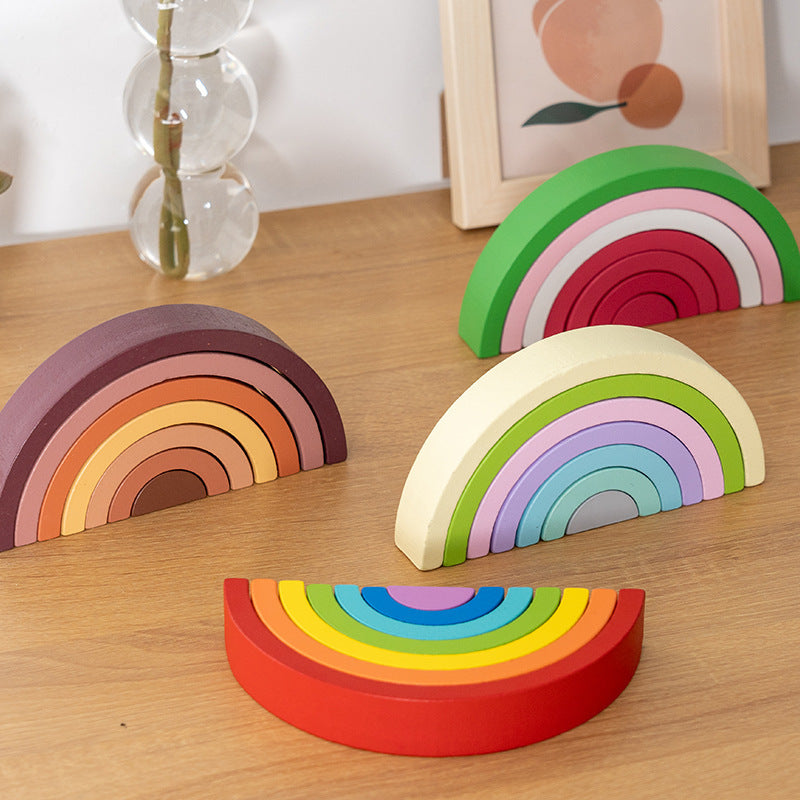 Colorful rainbow-shaped wooden toys on a wooden surface with a blurred background.