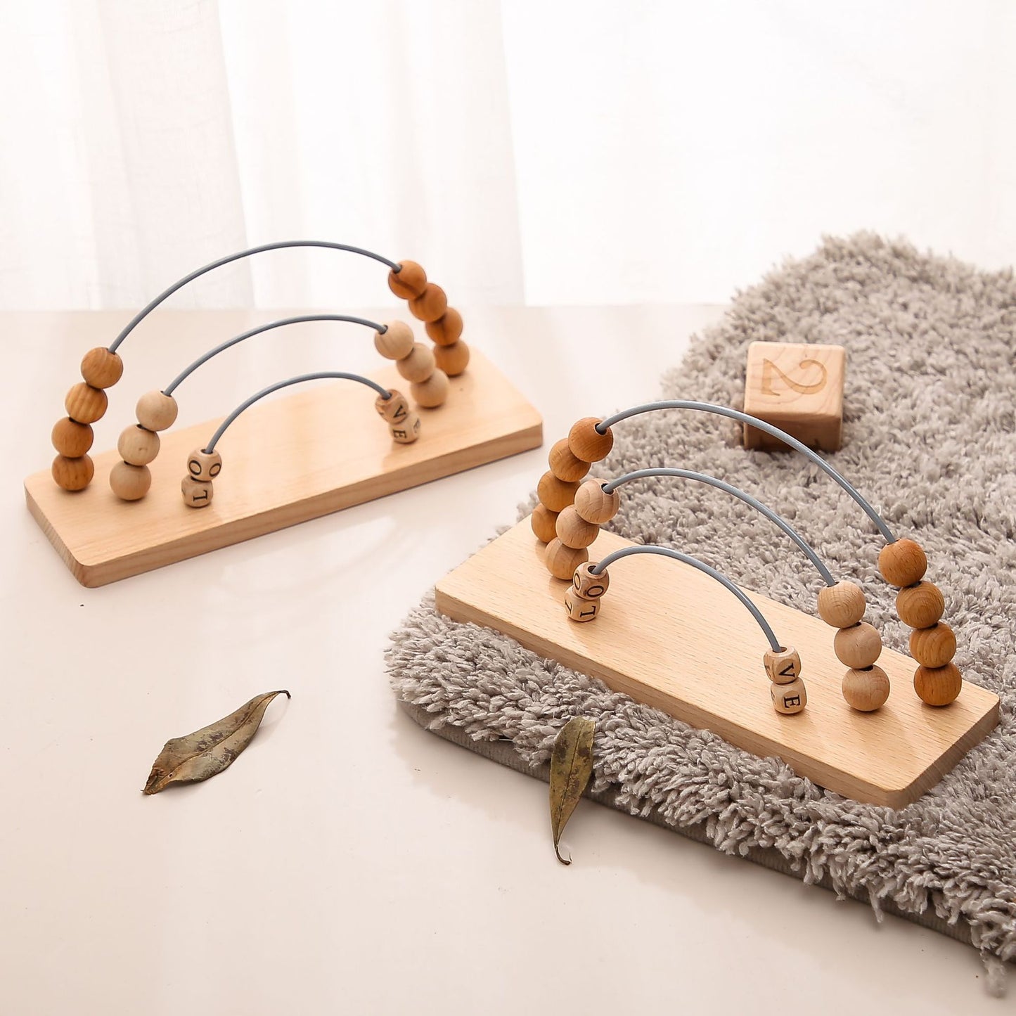 Wooden toy with beads and arches on a light surface with a soft rug.