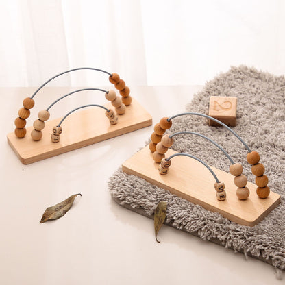 Wooden toy with beads and arches on a light surface with a soft rug.