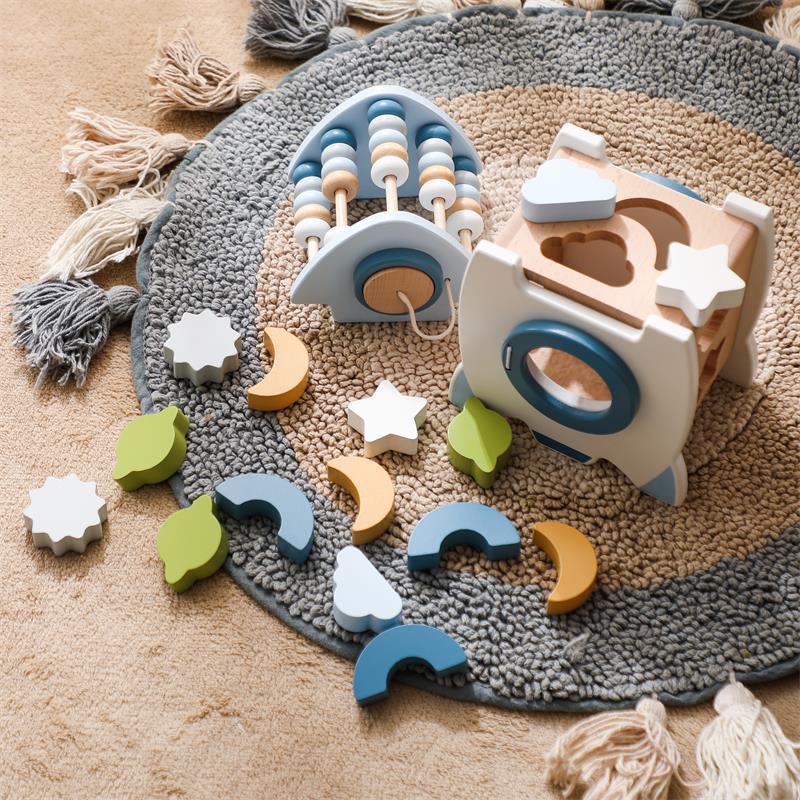 Wooden toys on a textured rug with colorful geometric shapes.