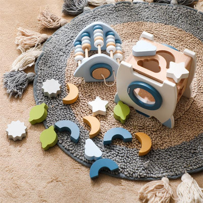 Wooden toys on a textured rug with colorful geometric shapes.