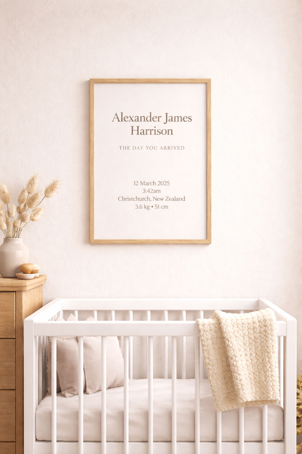 Framed birth announcement on a wall above a crib in a nursery.