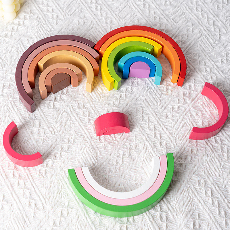 Set of colorful wooden rainbow toys on a textured white surface
