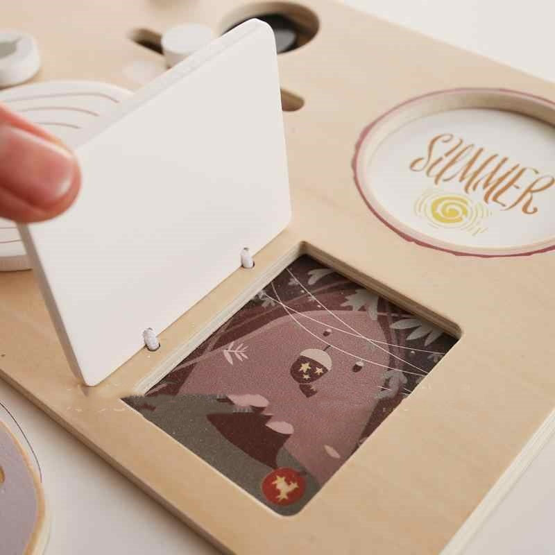 Wooden puzzle with a hand holding a piece labeled 'Summer'.