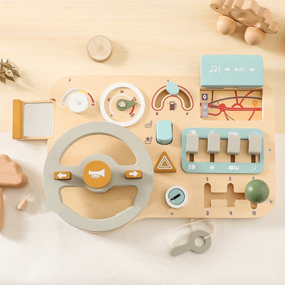 Wooden toy dashboard with various controls on a light wooden surface