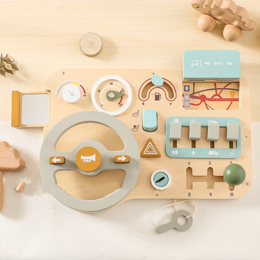Wooden toy dashboard with various controls on a light wooden surface