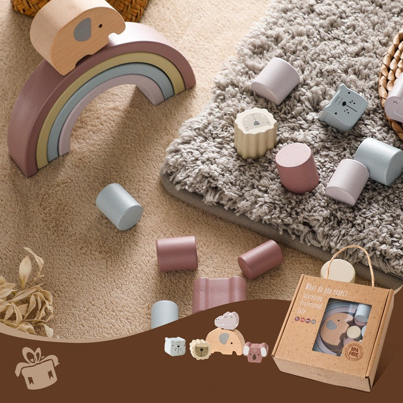 Wooden toys including a rainbow and cylindrical blocks on a carpeted floor.