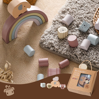 Wooden toys including a rainbow and cylindrical blocks on a carpeted floor.